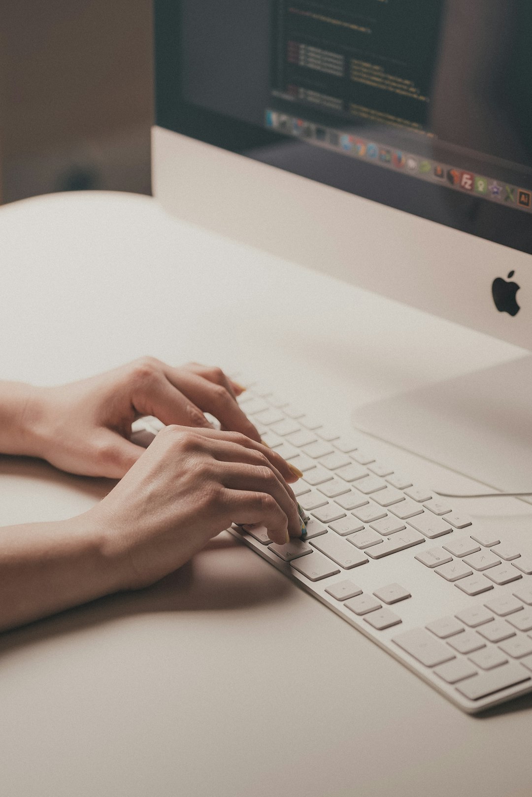 Female hands typing on a white keyboard